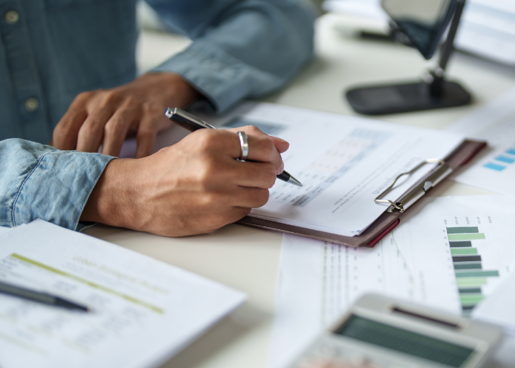 Woman doing paperwork while learning about the importance of Beneficiary Designations
